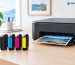 Epson 212XL black cyan magenta and yellow ink cartridges beside a printer with Inkrefill branding