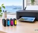 Epson 604XL black cyan magenta and yellow ink cartridges beside a printer with Inkrefill branding