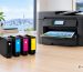 Epson 802XL black cyan magenta and yellow ink cartridges beside a WorkForce Pro printer